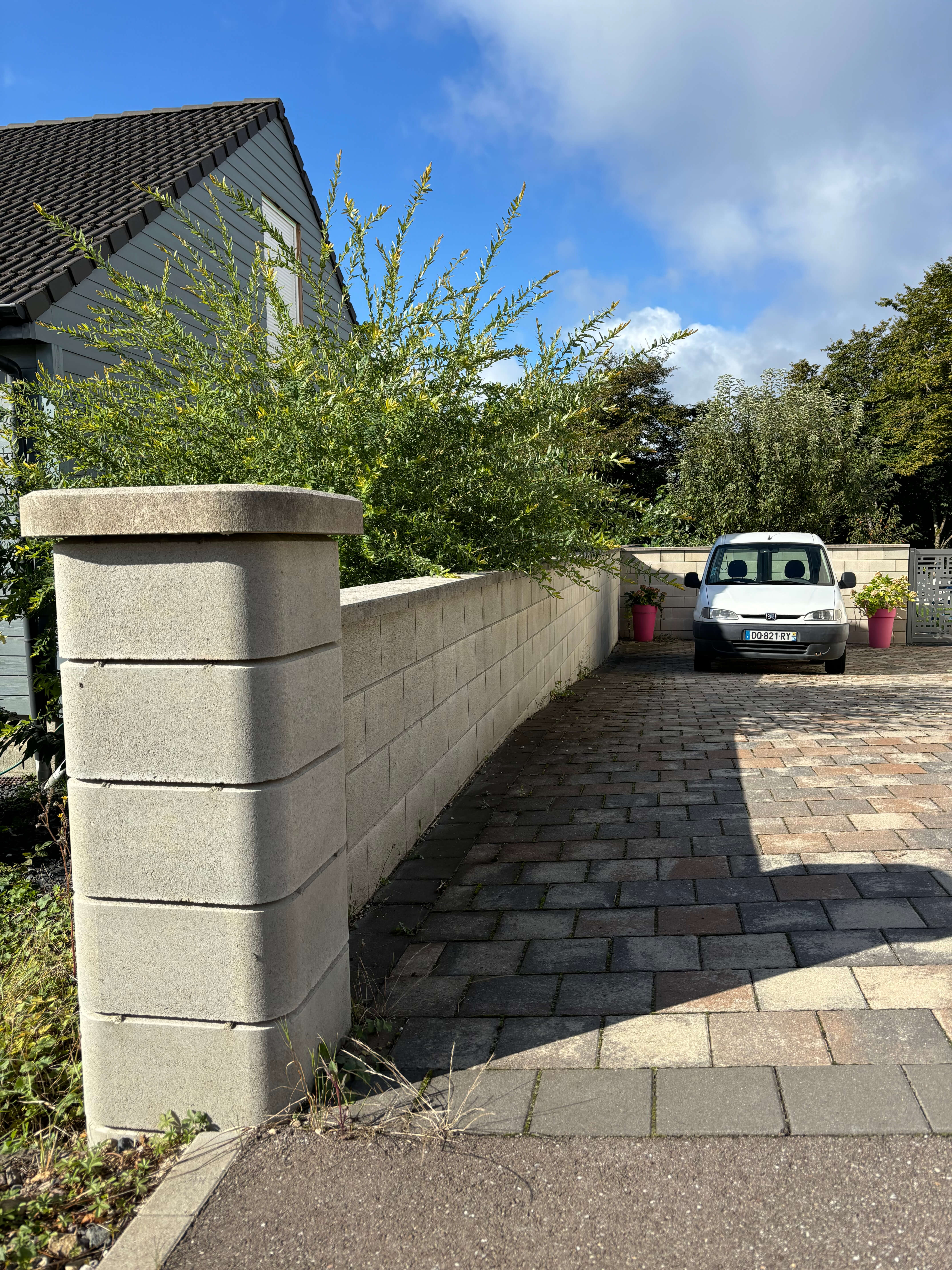 Mur coffrant fini de chez Gris Clair, pilier fini, pavé 20x20 Kronimuscolorie Dune 700, liseré anthracite.