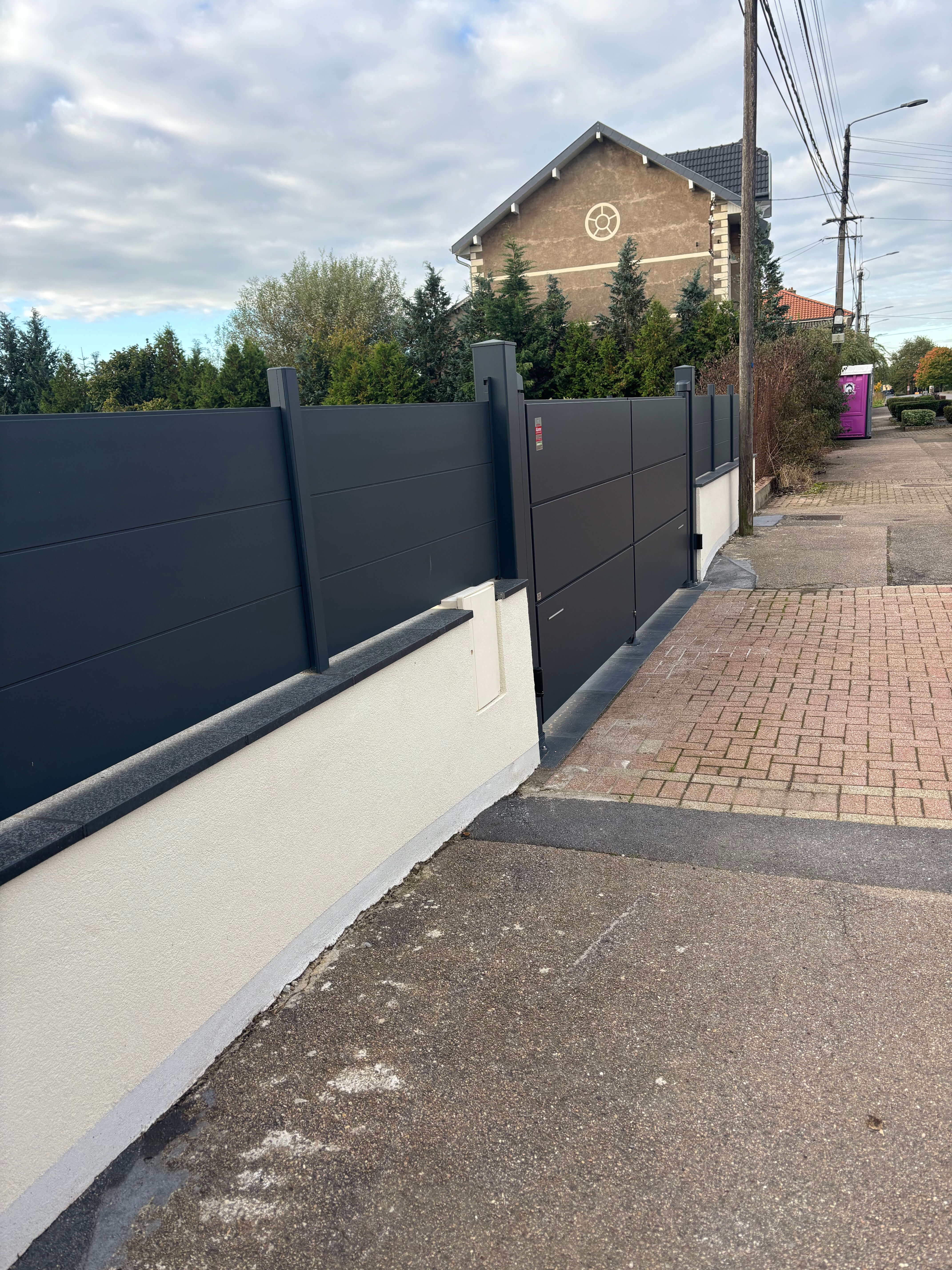 Mur coffrant avec cloture en aluminium et couvertine granit