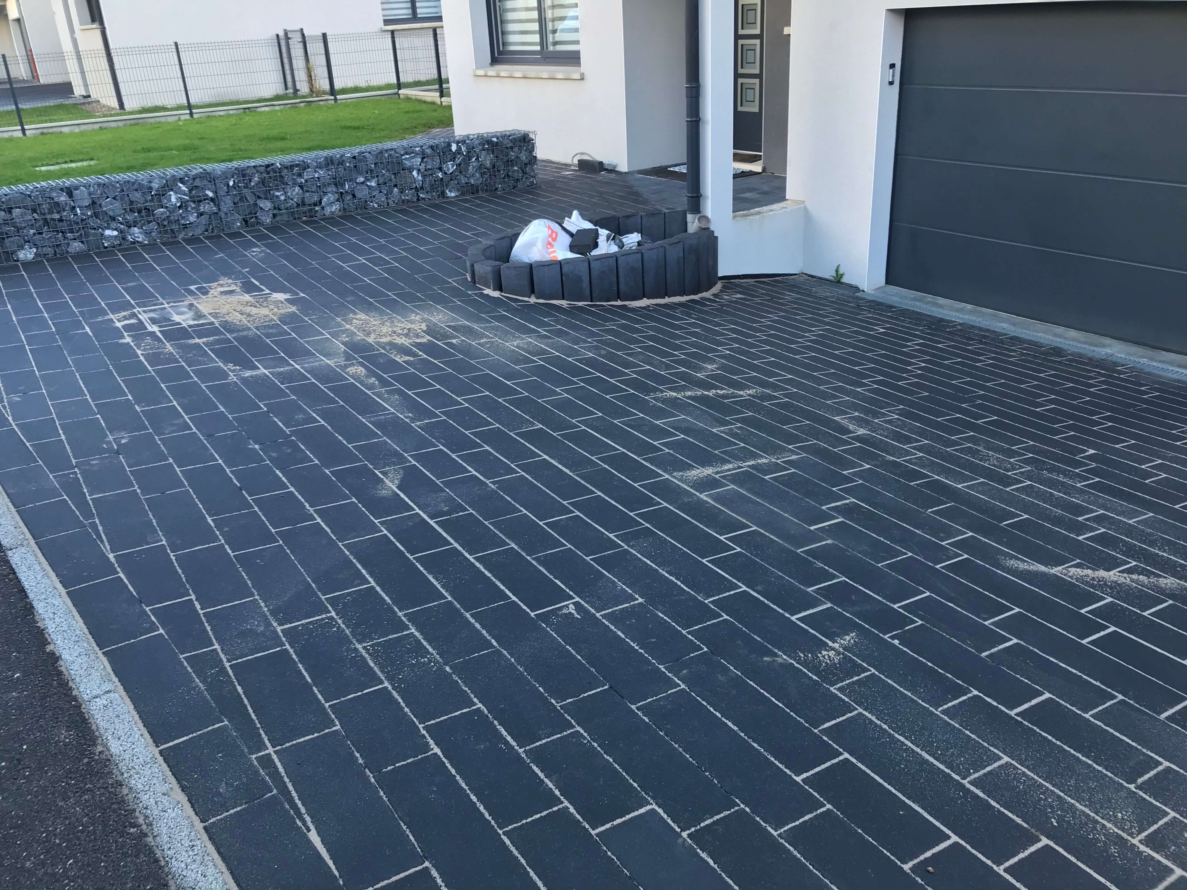 Pavés Agora Anthracite de chez Heinrich et Boch pour entrée de garage. Palissade Ondine en arrondie.